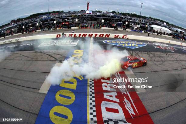 Joey Logano, driver of the Shell Pennzoil Ford, celebrates with a burnout after winning the NASCAR Cup Series Goodyear 400 at Darlington Raceway on...