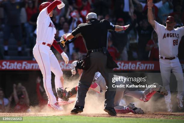 Shohei Ohtani of the Los Angeles Angels is called safe at the plate against Riley Adams of the Washington Nationals in the ninth inning at Angel...