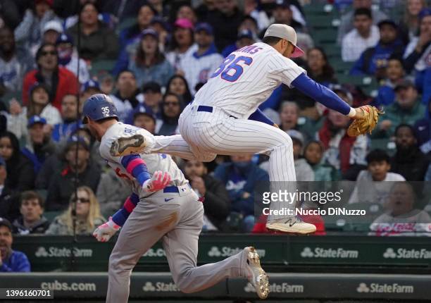 Cody Bellinger of the Los Angeles Dodgers is safe at first base against Alfonso Rivas of the Chicago Cubs on his RBI single during the fourth inning...
