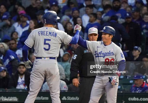 Freddie Freeman of the Los Angeles Dodgers is congratulated by first base coach Clayton McCullough of the Los Angeles Dodgers after his single during...