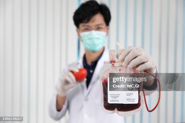 close up of blood bags on hand - blood group stock-fotos und bilder