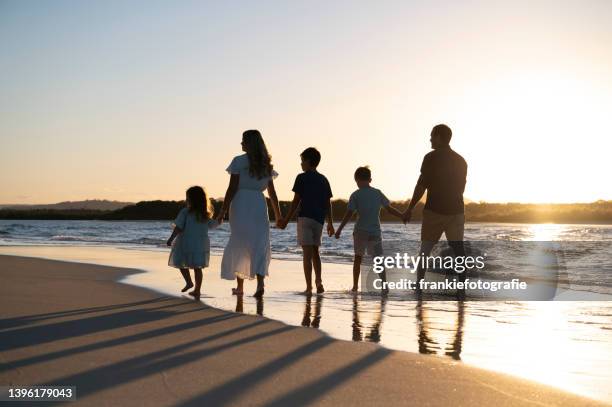 family of five walking the beach - queensland beaches stock pictures, royalty-free photos & images