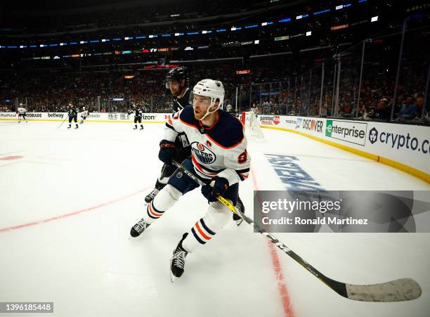 Connor McDavid of the Edmonton Oilers skates the puck against Anze Kopitar of the Los Angeles Kings in the third period of Game Four of the First...