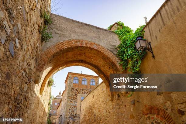 narrow alley with an arch in cáceres old town - extremadura stockfoto's en -beelden