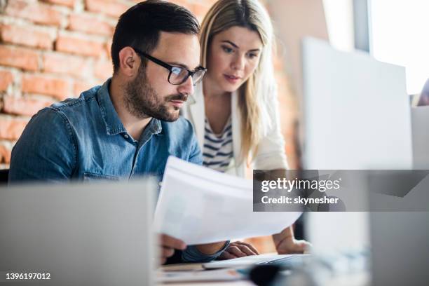 young business colleagues cooperating while working on laptop in the office. - report document stock pictures, royalty-free photos & images