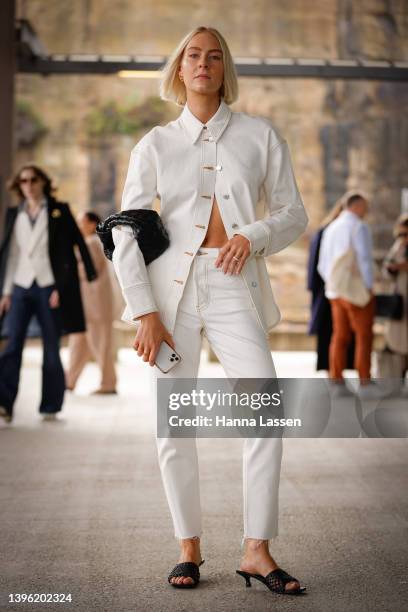 Lauren Burns wearing an off white Camilla and Marc denim and shirt, St agni heels and Bottega Veneta bag at Afterpay Australian Fashion Week 2022 on...