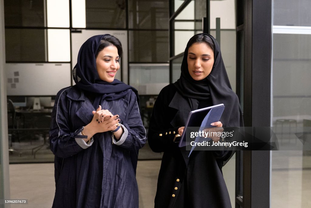 Riyadh business associates discussing data on digital tablet