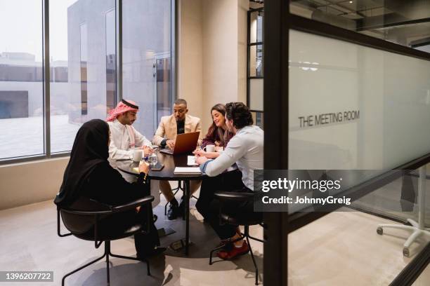 equipe de negócios de riyadh em conjunto na sala de reunião de coworking - oriente médio etnia - fotografias e filmes do acervo