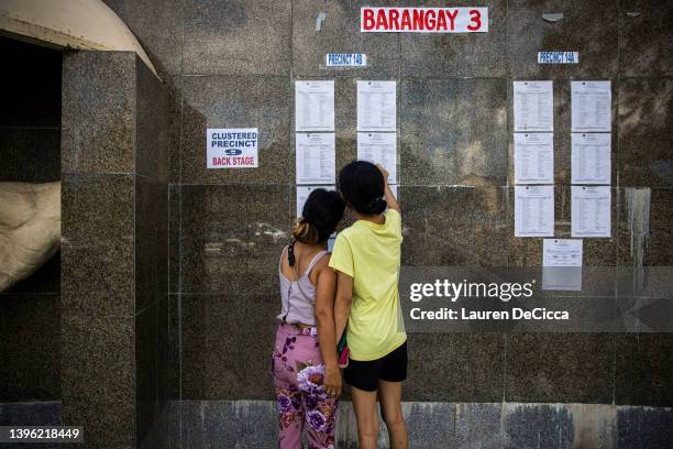 Voters check their registration before casting their vote for the presidential election at the Ilocos Norte Natioonal High School, which has been...