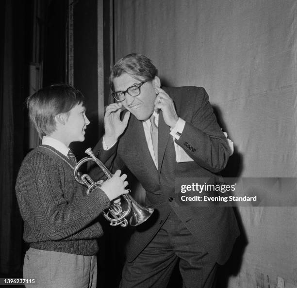 English actor and singer Dennis Waterman , holding a trumpet, with playwright Meredith Willson in rehearsal for the role of Winthrop Paroo in the...
