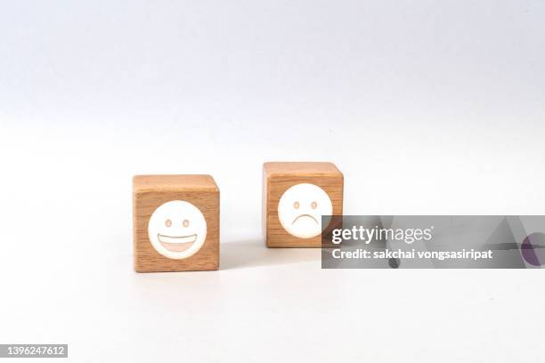 happy and sad symbol on wood blocks - anthropomorphic face stock pictures, royalty-free photos & images