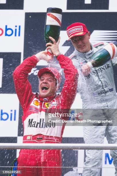 Rubens Barrichello of Brazil, driver of the Scuderia Ferrari Marlboro Ferrari F1-F2000 Ferrari V10 pours Mumm Cordon Rouge Champagne over himself as...