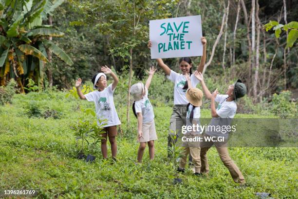 volunteer asian and children holding a sign with the message save the planet. - earthday foto e immagini stock