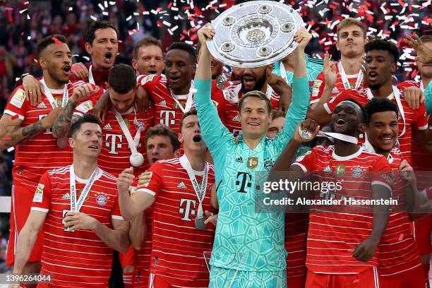 Manuel Neuer of FC Bayern Muenchen lifts The Bundesliga Meisterschale trophy following their sides finish as the Bundesliga champions during the...