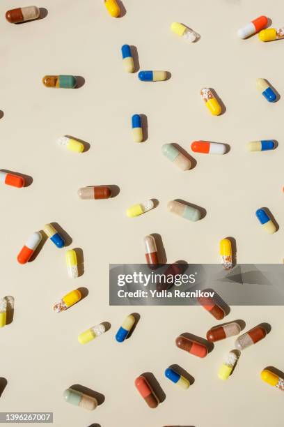 top view of various pills on the beige background - pillole foto e immagini stock