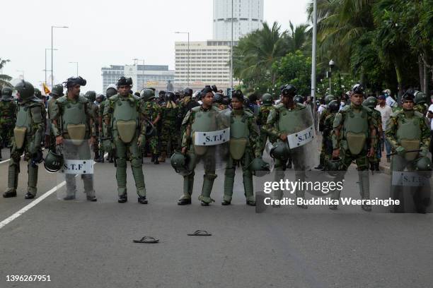 Riot police officers stand at a street during a clash on May 09, 2022 in Colombo, Sri Lanka. Sri Lankan President Gotabaya Rajapaksa has declared a...