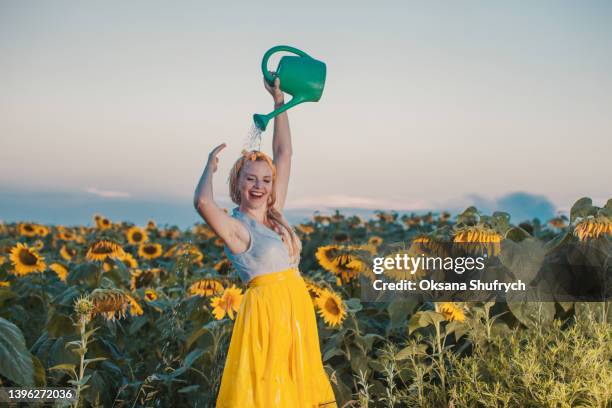 fashionable girl pours water from a watering can - hot glamour models stock pictures, royalty-free photos & images