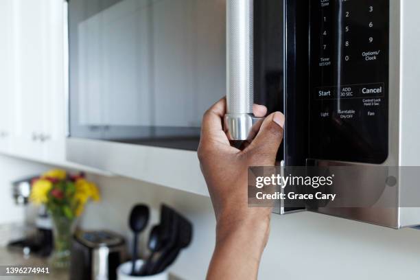 woman opens microwave - microwave photos et images de collection