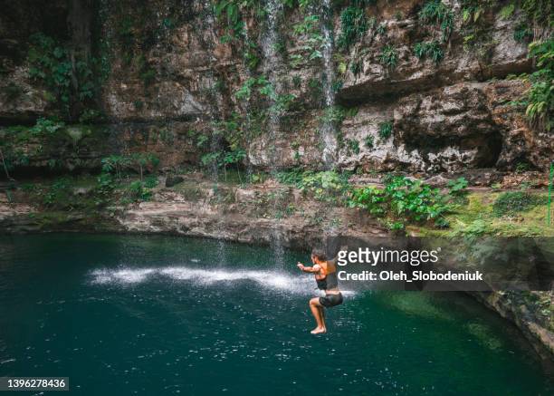 man jumping  into cenote in yucatan, mexico - yucatan stock pictures, royalty-free photos & images