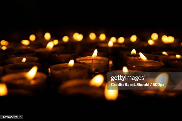 close-up of illuminated tea lights in darkroom - candle stock pictures, royalty-free photos & images