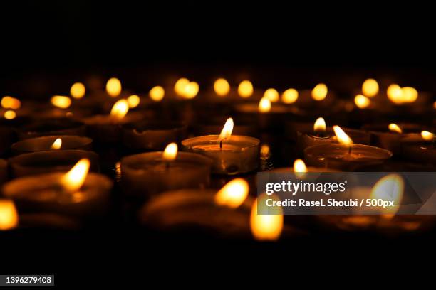 close-up of illuminated tea lights in darkroom - candle light stock pictures, royalty-free photos & images