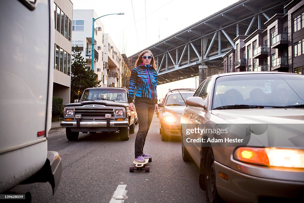 A young women riding a skateboard outside.