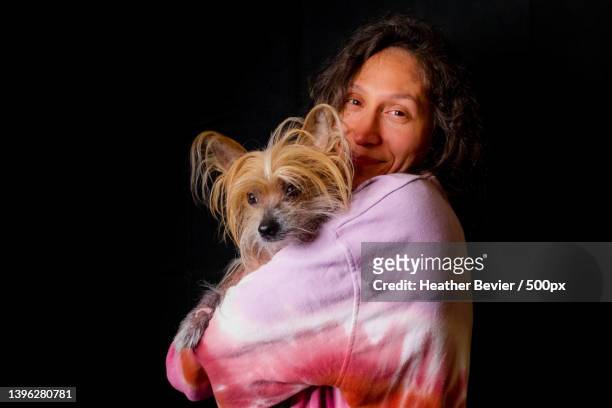 portrait of woman with chinese crested lap purebred dog against black background,washington,united states,usa - sans poils photos et images de collection