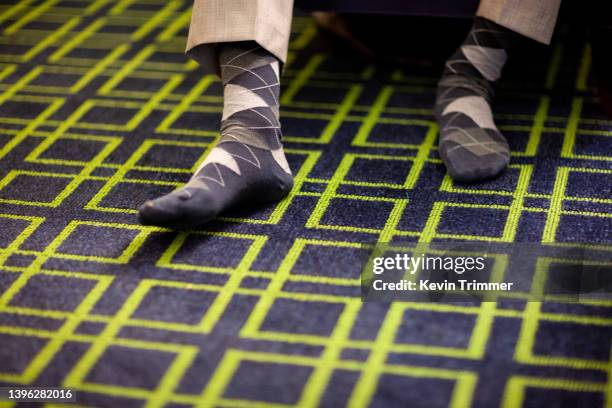 two feet wearing argyle socks on a graphic rug - argyle stock pictures, royalty-free photos & images