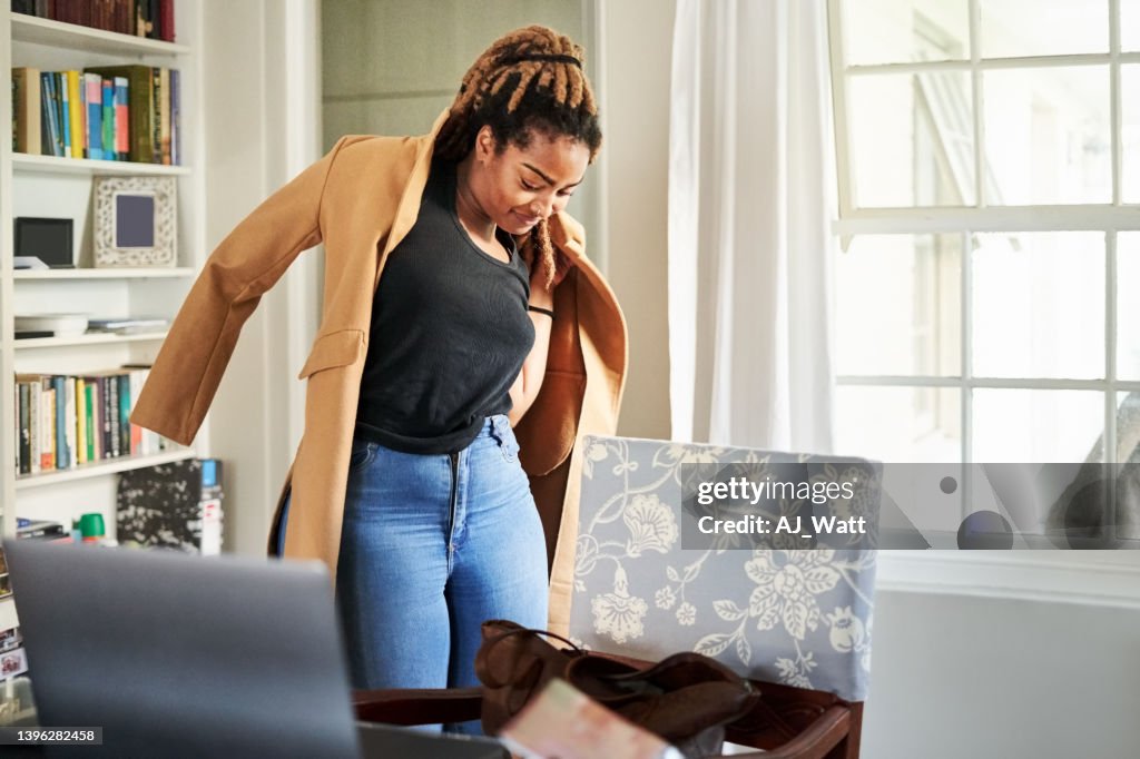 African woman putting on long coat