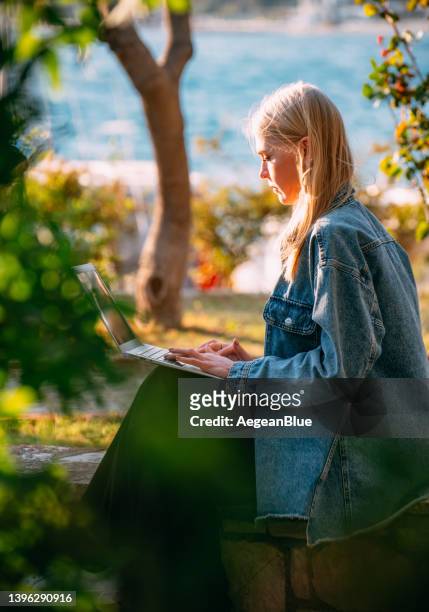 femme blonde travaillant avec un ordinateur portable sur le parc - parc informatique bureau ordinateur photos et images de collection