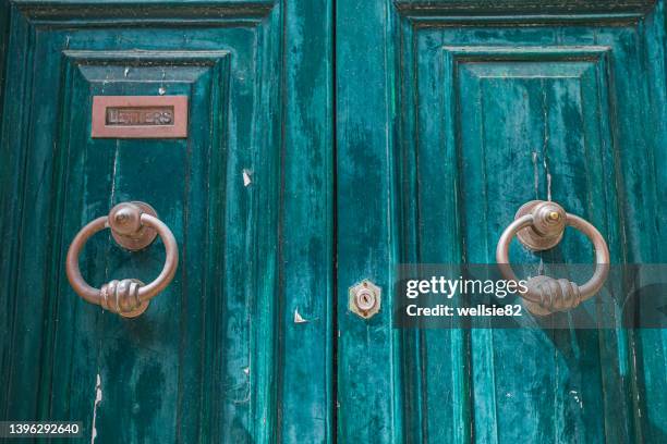 door knockers on a weathered door - malta city stock pictures, royalty-free photos & images