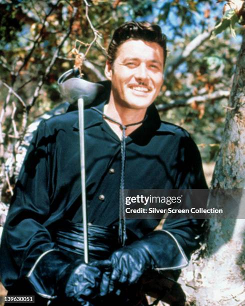 Guy Williams , US actor, in costume, holding his sword over his right shoulder, and smiling in a portrait, issued as publicity for the US television...