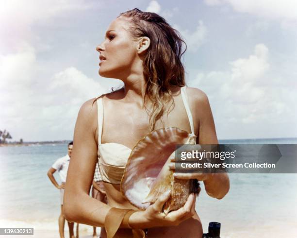 Ursula Andress, Swedish actress, wearing a white bikini and holding a conch shell in a publicity still issued for the film, 'Dr No', 1962. The James...
