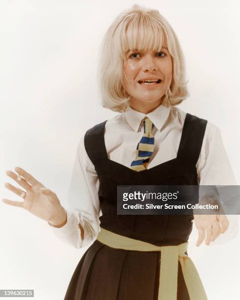Judy Geeson, British actress, dressed in school uniform in a studio portrait, against a white background, issued as publicity for the film, 'Three...