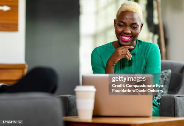 young woman using laptop in creative office - bleached hair woman stock pictures, royalty-free photos & images