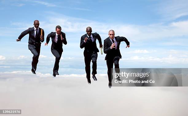 businessmen passing baton to colleague in the sky - young-urban-professional-person stock-fotos und bilder