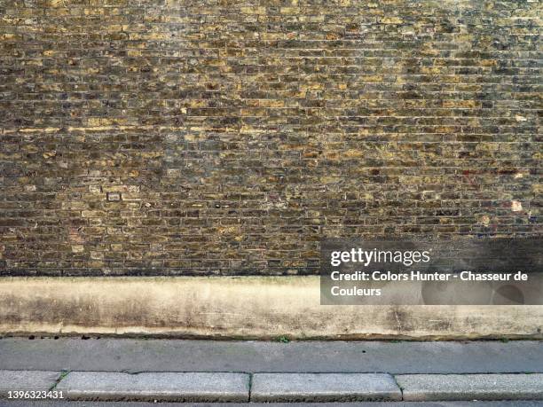 victorian old yellow and gray brick wall, cement and sidewalk in london - brick wall close up stock pictures, royalty-free photos & images