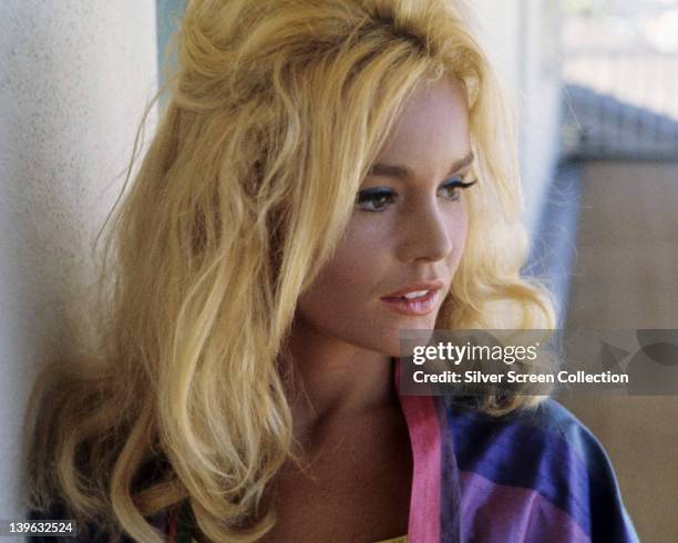 Tuesday Weld, US actress, with long blonde hair, wearing a pink, blue and purple blouse, circa 1965.