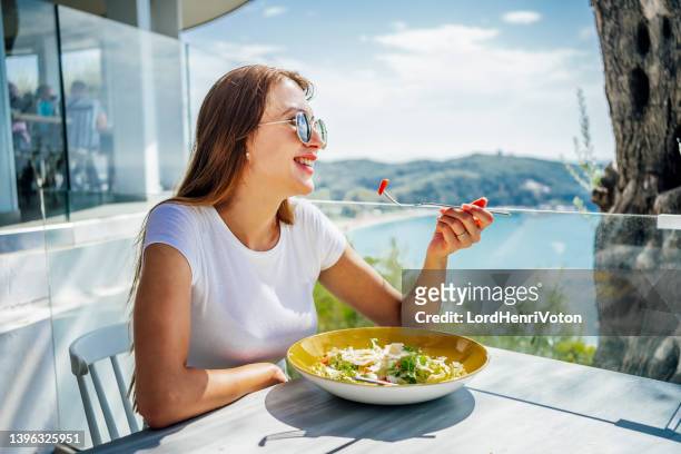 frau genießt das mittagessen mit schöner aussicht - balkon essen stock-fotos und bilder
