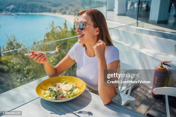 woman enjoying lunch with beautiful view - mediterranean food stockfoto's en -beelden