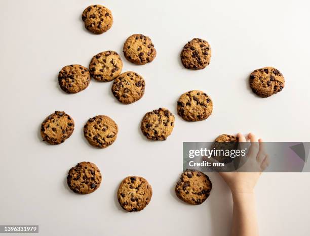 child taking  cookie - chocolate chip cookie on white stock pictures, royalty-free photos & images