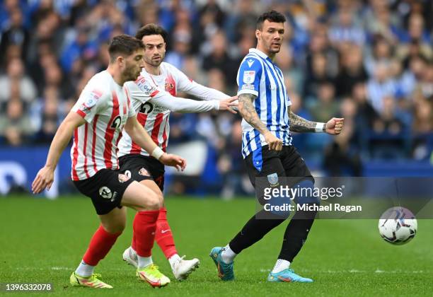 Marvin Johnson of Sheffield Wednesday is challenged by Lynden Gooch and Patrick Roberts of Sunderland during the Sky Bet League One Play-Off Semi...
