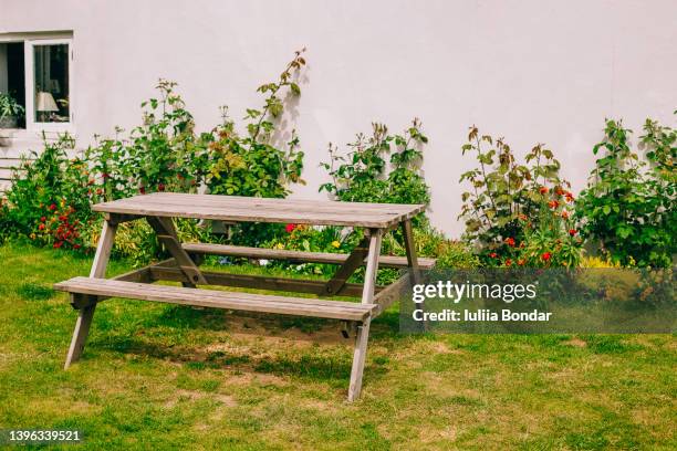 wooden table in garden - outdoor table stock-fotos und bilder