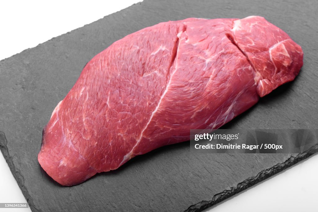 Raw fresh Chuck roll steak with herbs and salt on a cutting Board