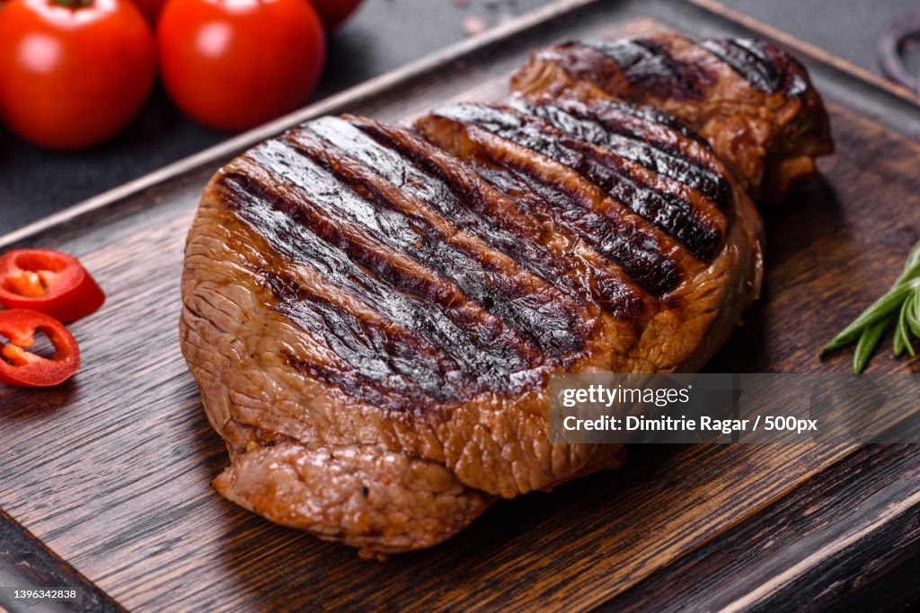 Cooked grilled Chuck eye roll steak on a chopping Board