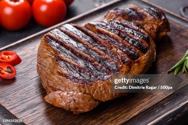cooked grilled chuck eye roll steak on a chopping board - grilled chuck steak stock pictures, royalty-free photos & images