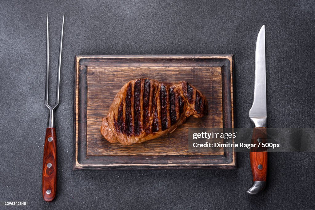 Cooked grilled Chuck eye roll steak on a chopping Board