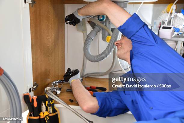 plumber repairing leak in sink of a house ok gesture - drain inspection stock-fotos und bilder