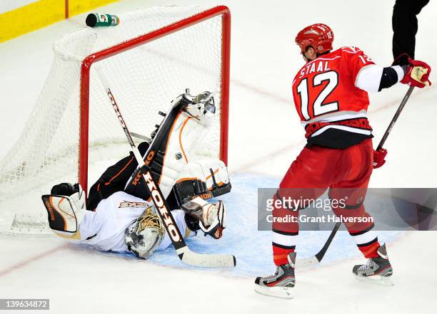 Eric Staal of the Carolina Hurricanes upends goaltender Jonas Hiller of the Anaheim Ducks at the RBC Center on February 23, 2012 in Raleigh, North...
