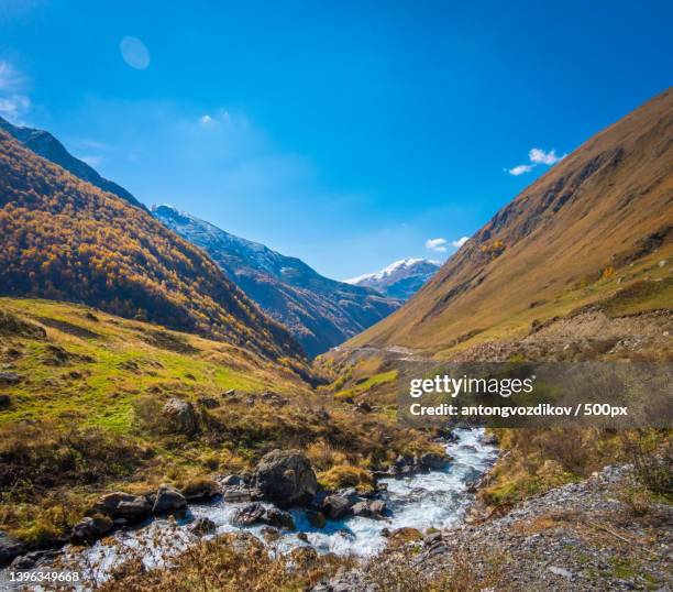 fast creek in valley amidst mountains - real time stock pictures, royalty-free photos & images